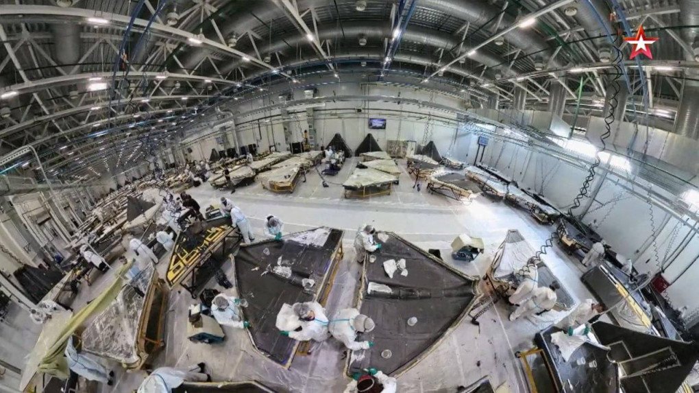 Técnicos con trajes protectores aplican materiales a los armazones de los drones en condiciones controladas en la zona de revestimiento final y laminación. (Fuente: Zvezda TV) Técnicos con trajes protectores aplican materiales a los armazones de los drones en condiciones controladas en la zona de revestimiento final y laminación. (Fuente: Zvezda TV)