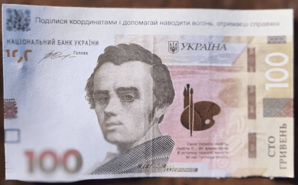 A fake 100-hryvnia banknote circulated by Russian forces features a QR code and hostile messaging printed across the top. (Photo: open source)