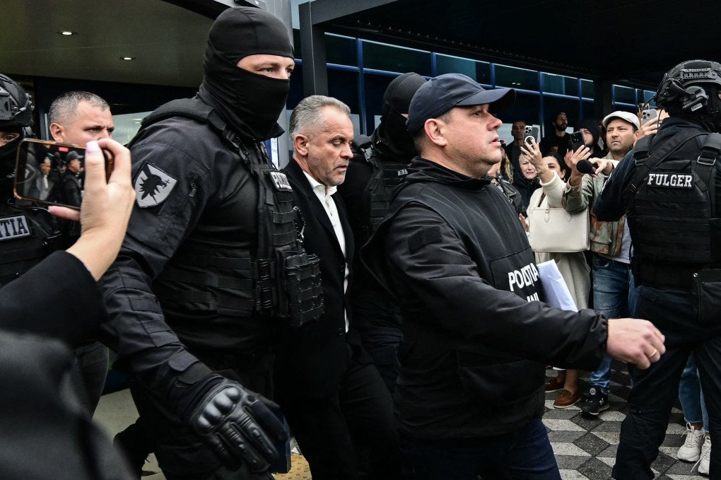 El oligarca moldavo Vladimir Plahotniuc, acusado de actuar en nombre de Rusia, sale del Aeropuerto Internacional de Chisinau escoltado por la policía, el 25 de septiembre de 2025, tras su extradición desde Grecia tras su detención a principios de julio. (Fuente: Daniel Mihailescu a través de Getty Images)