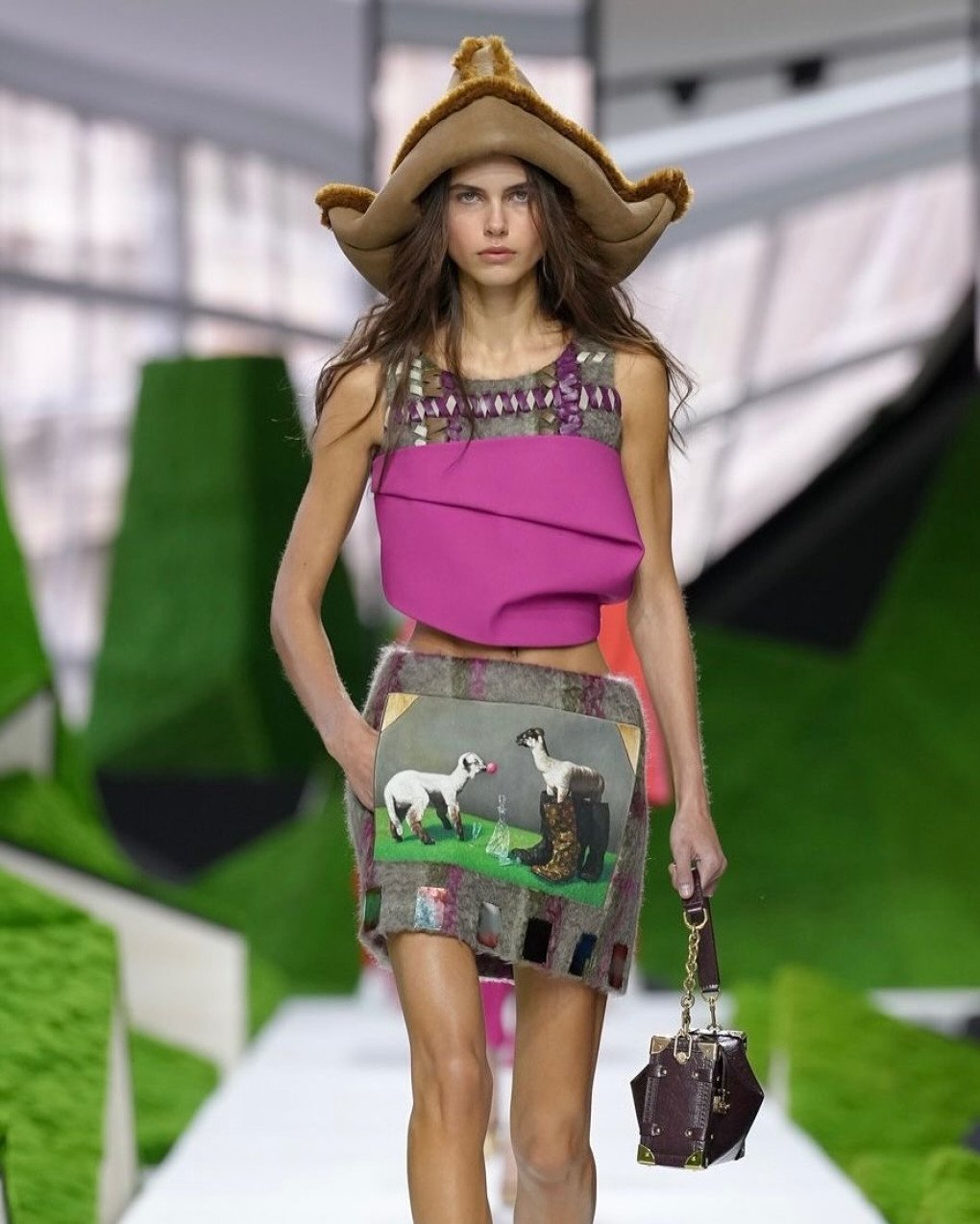 A model walks the runway showcasing a Louis Vuitton creation featuring a print of Nazar Strelyaiev-Nazarko's artwork Paramnesia (2023), where a lamb is depicted wearing luxury boots. (Source: Nazar Strelyaiev-Nazarko's/Instagram)