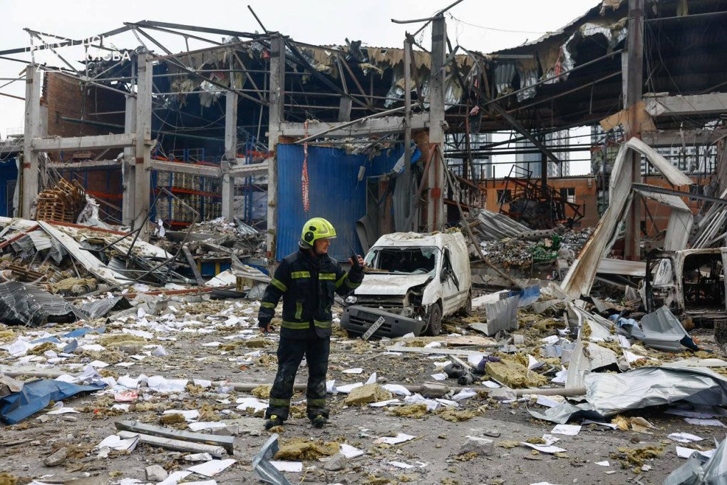 A firefighter stands outside a heavily damaged warehouse structure next to a crushed white delivery van during daytime cleanup operations. (Source: State Emergency Service of Ukraine) A firefighter stands outside a heavily damaged warehouse structure next to a crushed white delivery van during daytime cleanup operations. (Source: State Emergency Service of Ukraine)