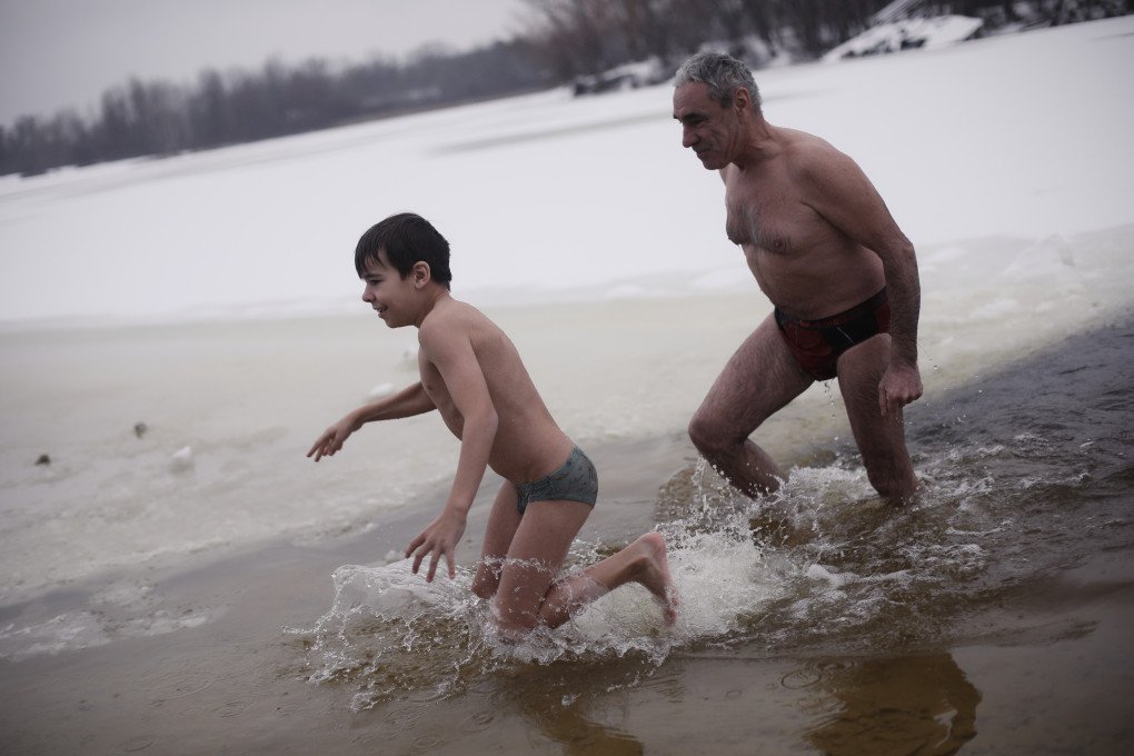 A father and son run out of the water, in Kyiv, Ukraine, January 6, 2026. (Photo: Lucile Brizard) A father and son run out of the water, in Kyiv, Ukraine, January 6, 2026. (Photo: Lucile Brizard)
