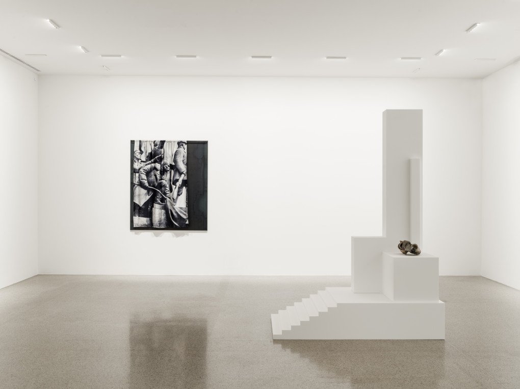 Victory (White Shelf) by Kadan is a reinterpretation of Vasyl Ermilov’s 1925 model of the Monument to Three Russian Revolutions. The original hammer-shaped form is rendered in white plywood and stripped of its communist symbolism. On top, a small assemblage of melted cups—found in the remains of a house in Ukraine’s Lysychansk destroyed by artillery shelling—rests on the structure. (Source: nikitakadan.com)