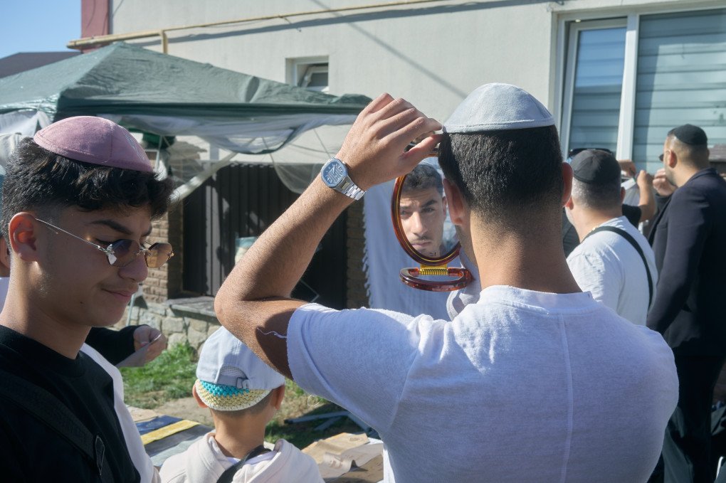 Young jewish pilgrims try out yarmulkes. Uman, Ukraine. September, 2025. Photo: Josh Olley/UNITED24 Media