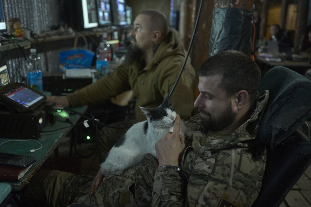A soldier from the 1st Separate Assault Brigade takes a break with his furry companion. Photo by Joshua Olley/UNITED24 Media