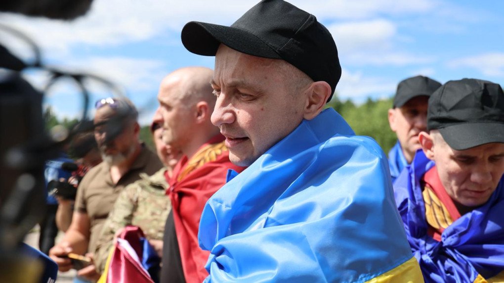 Ukrainian soldier with national flags draped over their shoulders after returning home in Ukraine, on June 26, 2026. (Source: Coordination Headquarters for the Treatment of Prisoners of War)