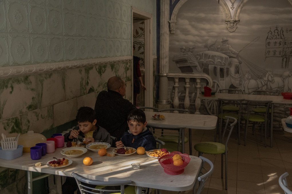 MYKOLAIV, UKRAINE - OCTOBER 8, 2023: Children evacuated from the Kherson Region share a meal in a canteen at a refugee reception center in Mykolaiv, a southern Ukrainian city. Since its liberation on November 11, 2022, after over eight months under Russian occupation, Kherson has endured relentless Russian shelling. Perched along the Dnipro River, the city lies on the volatile front line, where Ukrainian forces have been trying to breach Russian positions on the opposite bank. With the danger escalating, many families—especially those with children—have chosen to evacuate, while others have decided to remain despite the risks. (Photo by ROMAN PILIPEY/AFP via Getty Images)