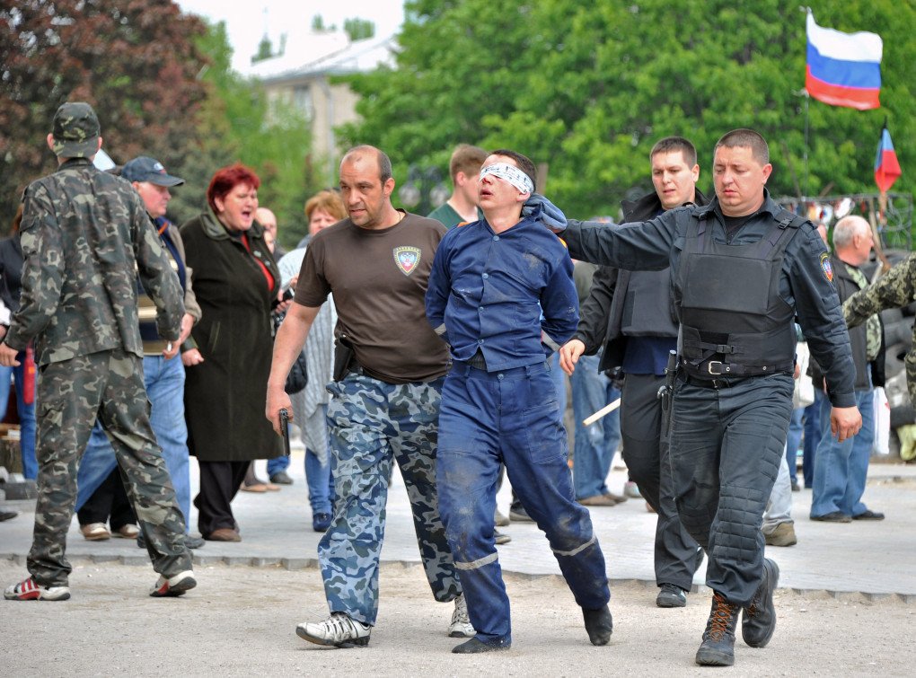 Russian-backed militants carry a blindfolded man outside the seized regional state building in Donetsk, in the East of Ukraine, on May 5, 2014. (Source: Getty Images) Russian-backed militants carry a blindfolded man outside the seized regional state building in Donetsk, in the East of Ukraine, on May 5, 2014. (Source: Getty Images)