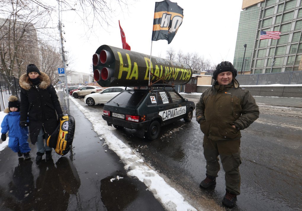 Un activista del Movimiento de Liberación Nacional (MLN), afín a Putin, posa para una foto junto a su coche, donde luce una bandera soviética y una réplica simbólica del misil RS-28 "Sarmat" en el techo, con el letrero "Regresar a Washington con las misiones de vuelo". Foto: Colaborador/Getty Images.