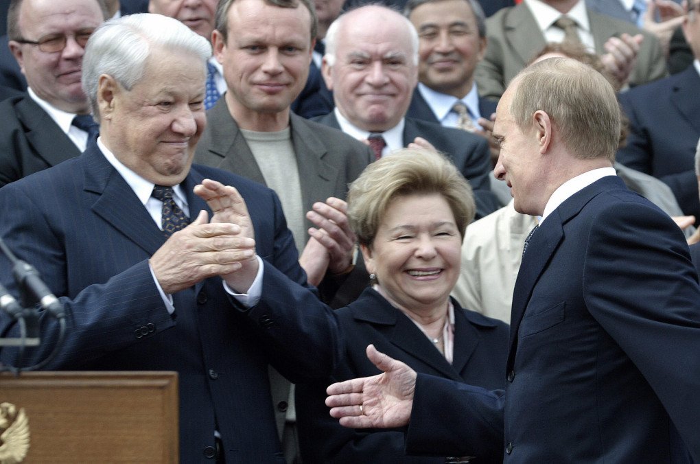 A picture taken 12 June 2003 shows Russian leader Vladimir Putin (R) greeting First President of Russia Boris Yeltsin (L) and his wife Naina Yeltsina (C) on Red square in Moscow. (Photo: Alexender Nemenov via Getty Images) 