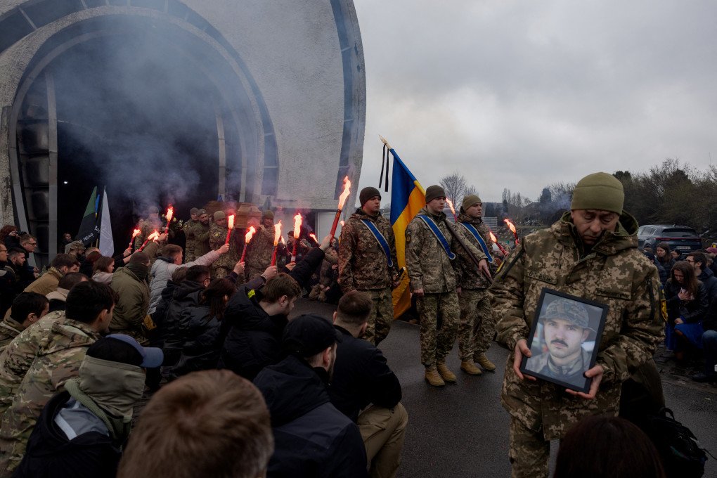 KYIV, MARCH 25, 2025: Mourners hold smoke flares as Ukrainian soldiers carry the coffin of Oleksandr Oliinyk, a Hospitaller and Ukrainian serviceman known by the callsign “Bohush,” during his funeral in Kyiv, Ukraine. (Photo: TETIANA DZHAFAROVA  via Getty Images)