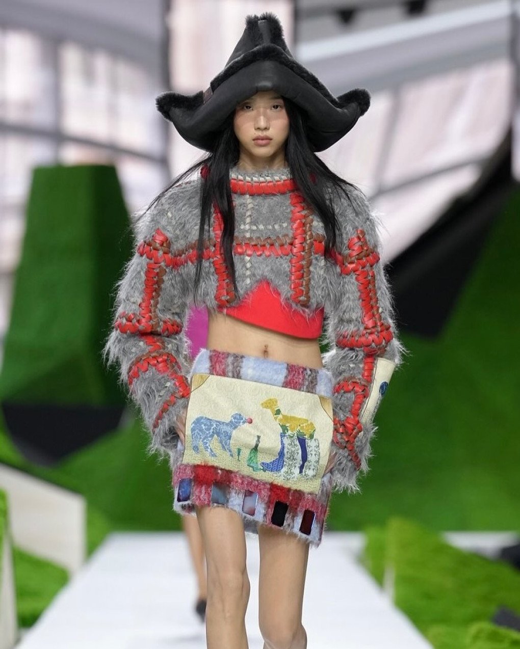 A model walks the runway showcasing a Louis Vuitton creation featuring a print of Nazar Strelyaiev-Nazarko's artwork Paramnesia (2023), where a lamb is depicted wearing luxury boots. (Source: Nazar Strelyaiev-Nazarko's/Instagram)