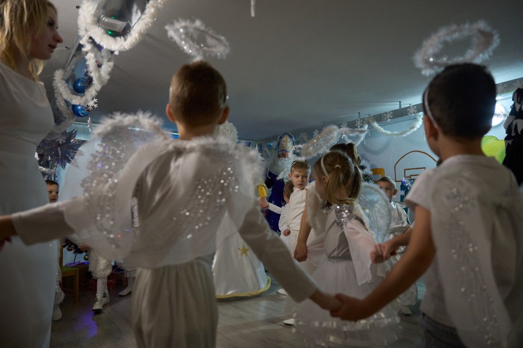 Children in an underground kindergarten in Zaporizhzhia stand in a circle holding hands. Zaporizhzhia region, Ukraine, December 2025. Photo by Mykyta Shandyba / UNITED24 Media.