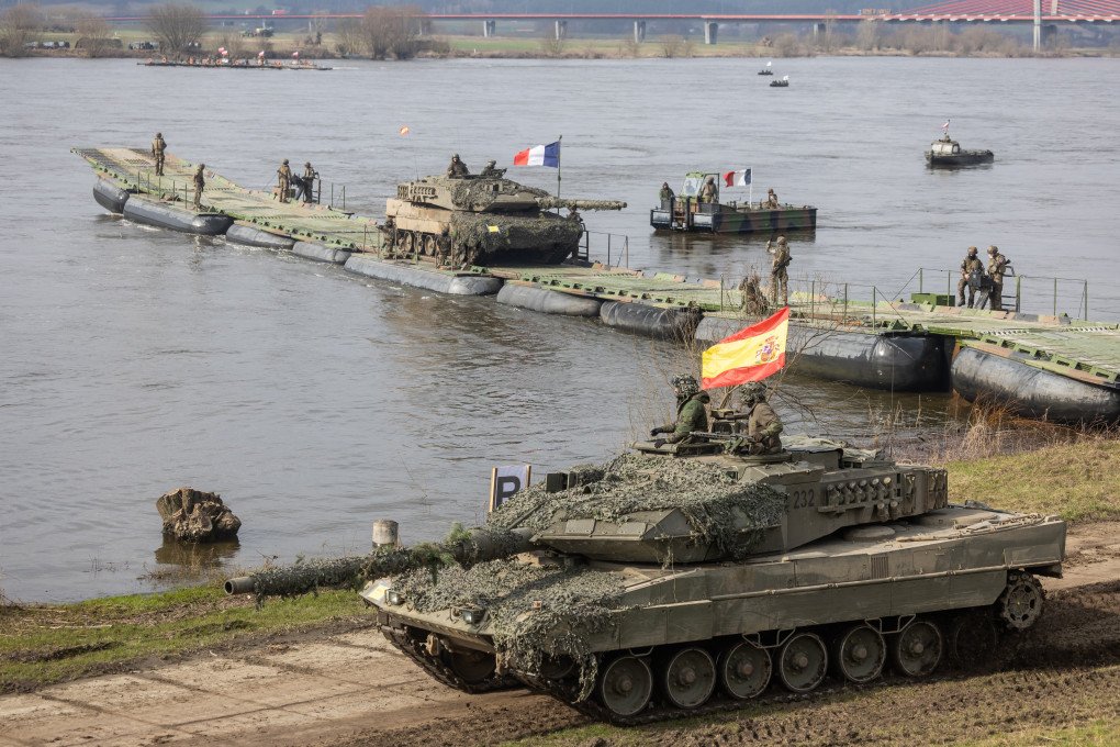 Soldiers from Spain drive a Leopard tank after crossing the Vistula river as they take part in the NATO DRAGON-24 military exercise in Korzeniewo, northern Poland, March 4, 2024. (Source: Getty Images)