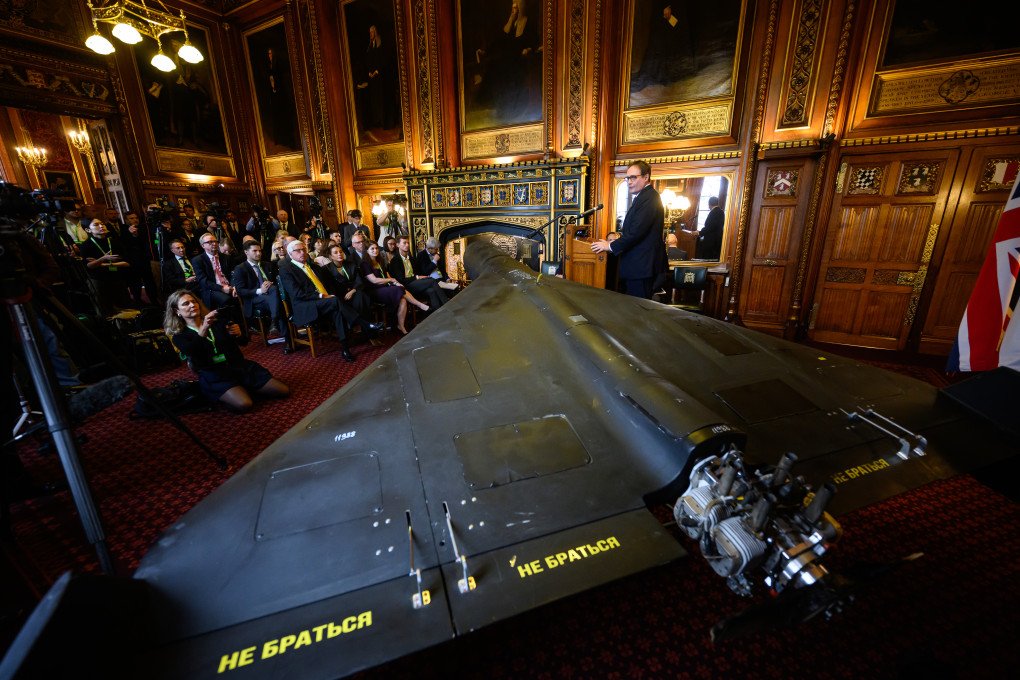 Tom Tugendhat speaks beside a downed Iranian-made Shahed-136 drone displayed at the UK Parliament in London, October 14, 2025. (Source: Getty Images)