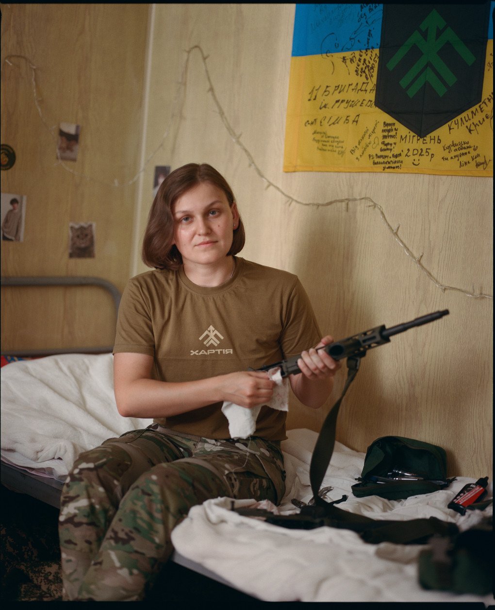 Kep, 27 years old, an operations planner in the 13th Khartiia Brigade, poses while cleaning her rifle, Kharkiv region, July, 2025. (Source: Joshua Olley) Kep, 27 years old, an operations planner in the 13th Khartiia Brigade, poses while cleaning her rifle, Kharkiv region, July, 2025. (Source: Joshua Olley)
