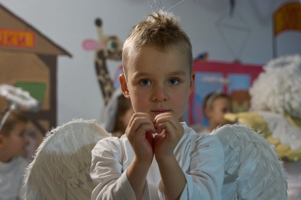 A boy looks into the camera while holding his hands in a heart shape at one of Zaporizhzhia’s underground kindergartens, Zaporizhzhia region, Ukraine, December 2025. Photo by Mykyta Shandyba / UNITED24 Media.