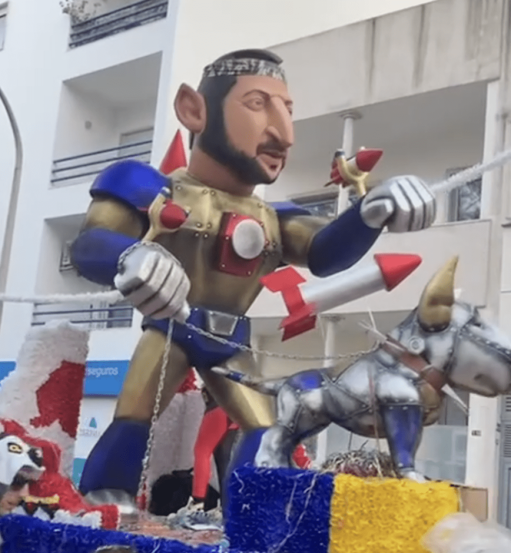 A carnival float featuring a caricature of Volodymyr Zelenskyy in knightly armor with rockets, accompanied by a robotic dog, parading at the Entrudo Carnival in Portugal. (Source: Nataliia/Threads)
