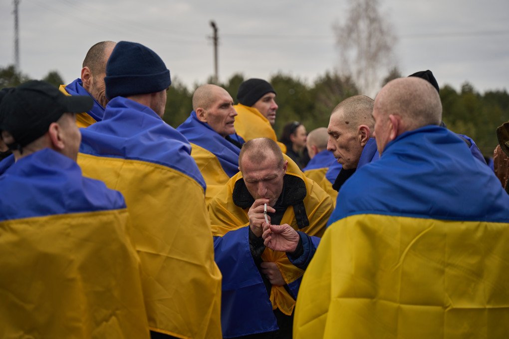 Freed Ukrainian defenders gather around each other, one of them is lighting the cigarette of another released serviceman. March 6, 2026, undisclosed location, Ukraine. Photo by Mykyta Shandyba, UNITED24 Media