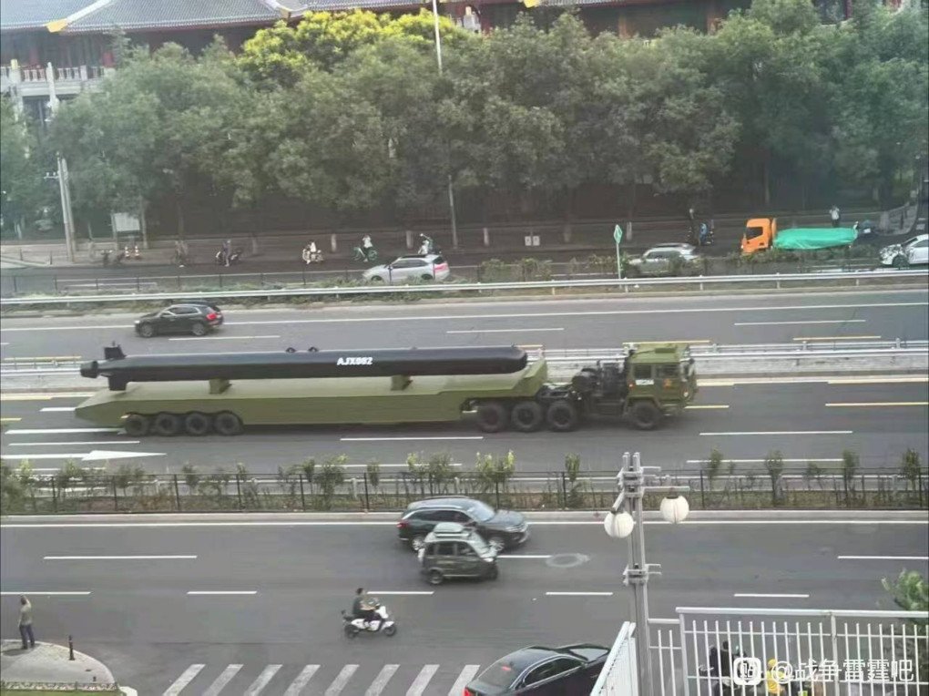 Large naval drone AJX002 carried on a trailer along a highway in China, escorted by a military vehicle. (Photo: Open source)