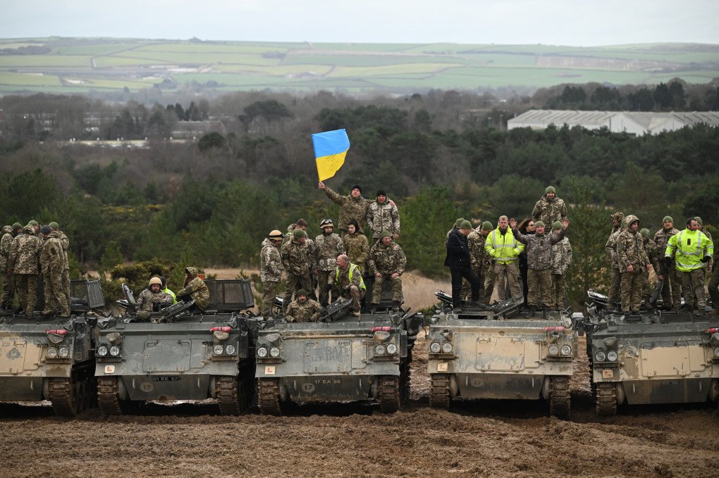 Ukrainian army volunteers pose on Driver Tank Trainers (DTTs) as they receive tank training at a military base on February 23, 2023 in Southern England.  (Photo by Leon Neal/Getty Images)