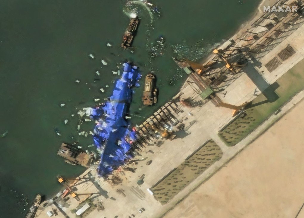 Maxar imagery shows continued efforts to conceal the damaged destroyer at Hambuk Shipyard one day after the failed launch on May 25. The ship remains on its side along the dock, draped in blue tarps, with minimal visible repair activity. (Source: Getty Images) Maxar imagery shows continued efforts to conceal the damaged destroyer at Hambuk Shipyard one day after the failed launch on May 25. The ship remains on its side along the dock, draped in blue tarps, with minimal visible repair activity. (Source: Getty Images)