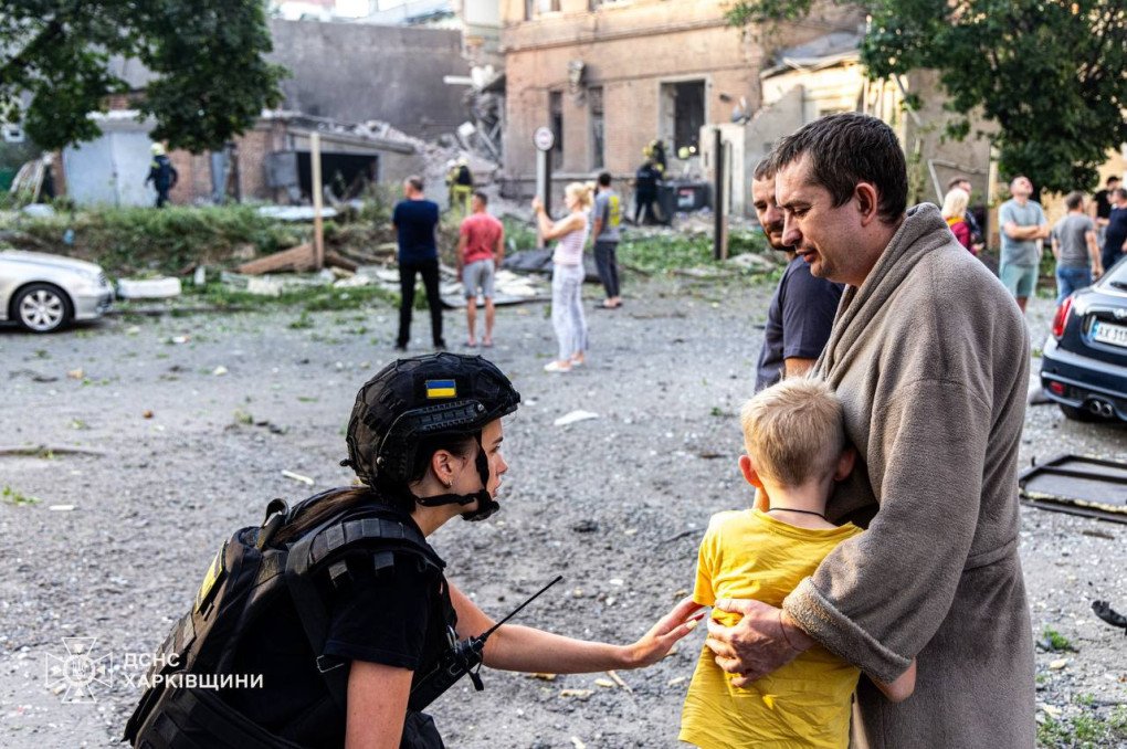 Rescue worker providing aid to a child affected by the Russian drone strike on Kharkiv, July 11, 2025. (Source: SES)