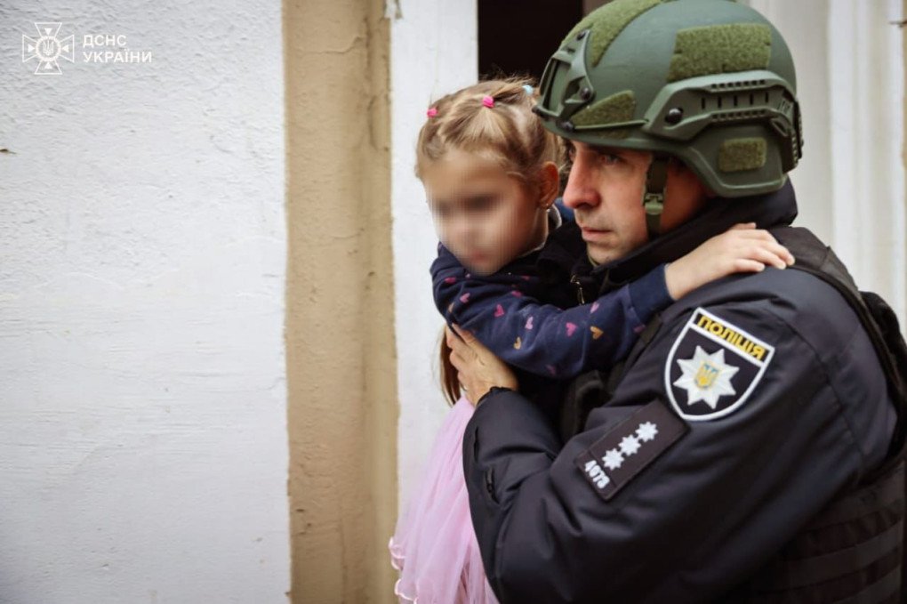 A Ukrainian police officer holds an evacuated child from the targeted private kindergarten in Kharkiv. (Source: Ukrainian President Volodymyr Zelenskyy)