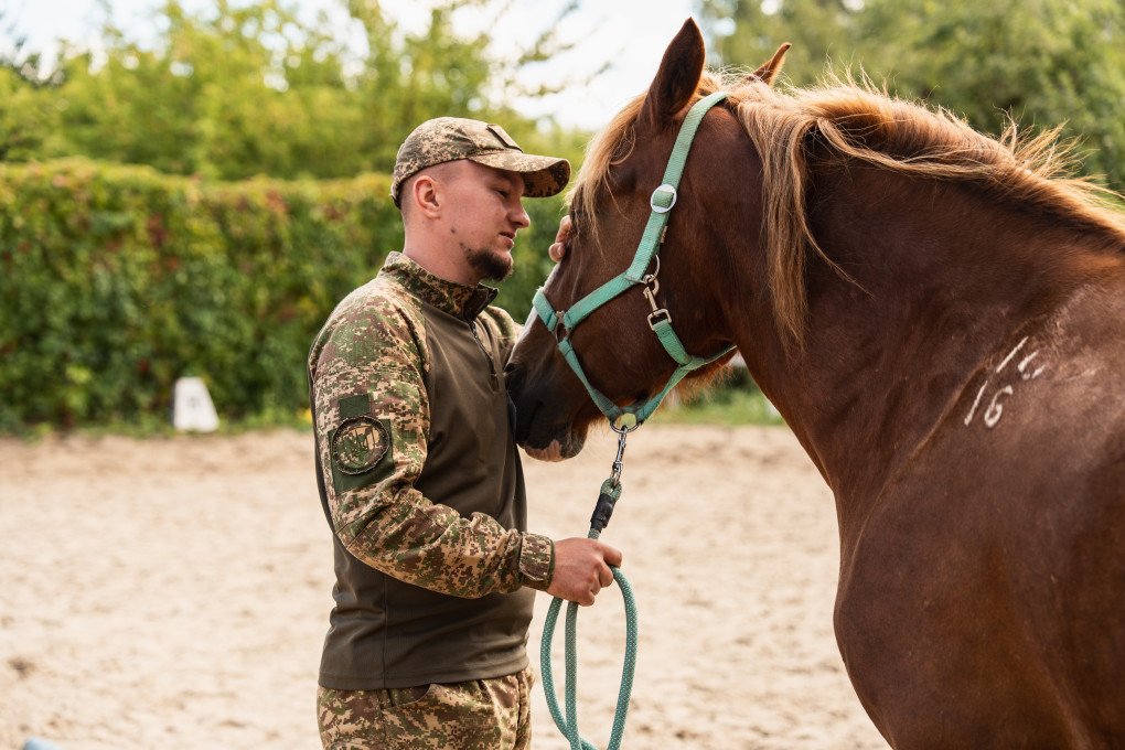 Rubizh Brigade defender Raion commends his partner after clearing the arena obstacles. September 2026, Kyiv region. (Photo by Nika Lastvika/EquiReHab Ukraine) Rubizh Brigade defender Raion commends his partner after clearing the arena obstacles. September 2026, Kyiv region. (Photo by Nika Lastvika/EquiReHab Ukraine)
