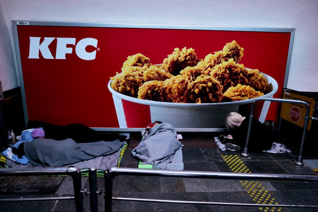 Kyiv residents take shelter in a metro station, tens of meters underground, in front of a KFC billboard. Kyiv, Ukraine, October 6, 2026 (Photo: Louis Beaudemont/UNITED24 Media)