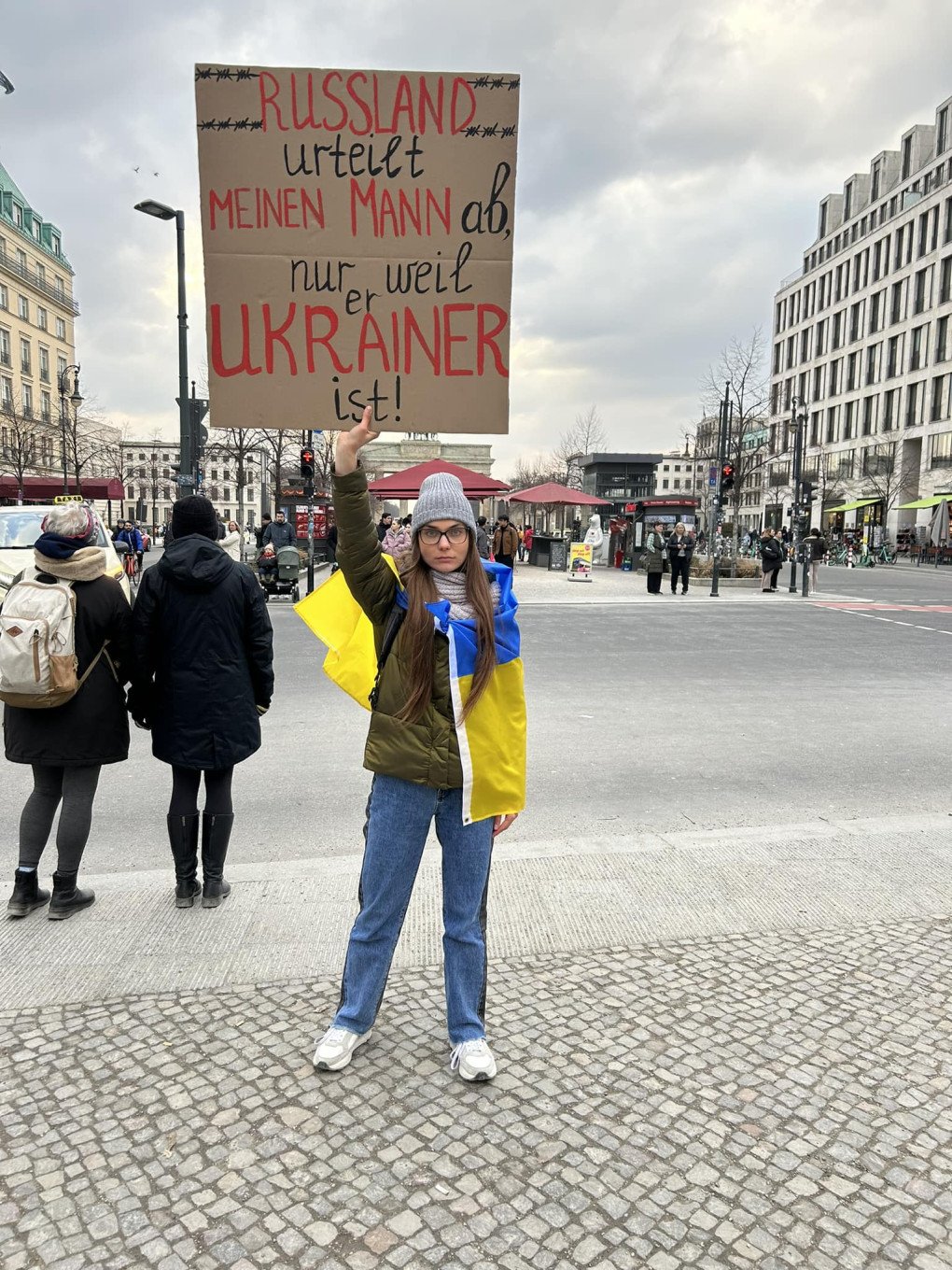 Liusiena Zinovkina, Kostiantyn Zinovkin’s wife, at a protest in Germany holds a sign in German which says “Russia is prosecuting my husband just for being a Ukrainian.” Photo from Liusiena’s Facebook.