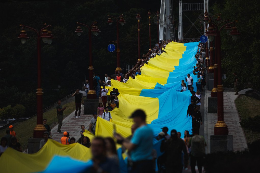 People hold a 430-meter-long Ukrainian flag along the park pedestrian bridge over the Dnipro River during the “Ukraine is united” political performance on August 28, 2022 in Kyiv, Ukraine. (Photo by Yurii Stefanyak via Getty Images) People hold a 430-meter-long Ukrainian flag along the park pedestrian bridge over the Dnipro River during the “Ukraine is united” political performance on August 28, 2022 in Kyiv, Ukraine. (Photo by Yurii Stefanyak via Getty Images)