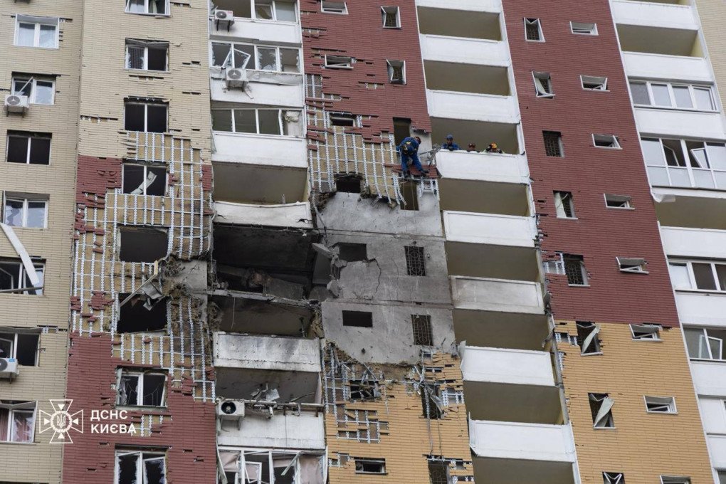 Edificio residencial destruido en Kyiv tras impacto de misil ruso con varios pisos colapsados y rescatistas trabajando en balcones.