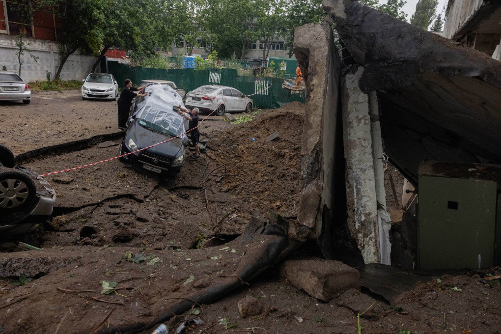 People cover a car with a plastic wrap next to a crater near a damaged residential building following a Russian missile strike on the Ukrainian capital of Kyiv on July 6, 2026, amid the Russian invasion in Ukraine. (Photo by Tetiana DZHAFAROVA / AFP via Getty Images) People cover a car with a plastic wrap next to a crater near a damaged residential building following a Russian missile strike on the Ukrainian capital of Kyiv on July 6, 2026, amid the Russian invasion in Ukraine. (Photo by Tetiana DZHAFAROVA / AFP via Getty Images)
