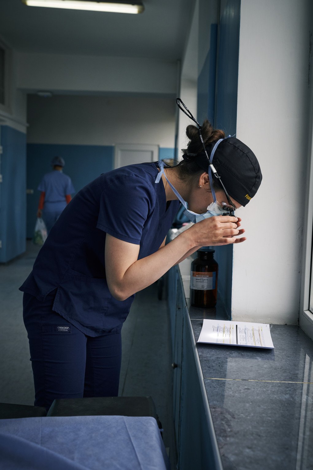 A surgeon from the “Face to Face” mission reviews patient notes using surgical loupes. Photo: Josh Olley