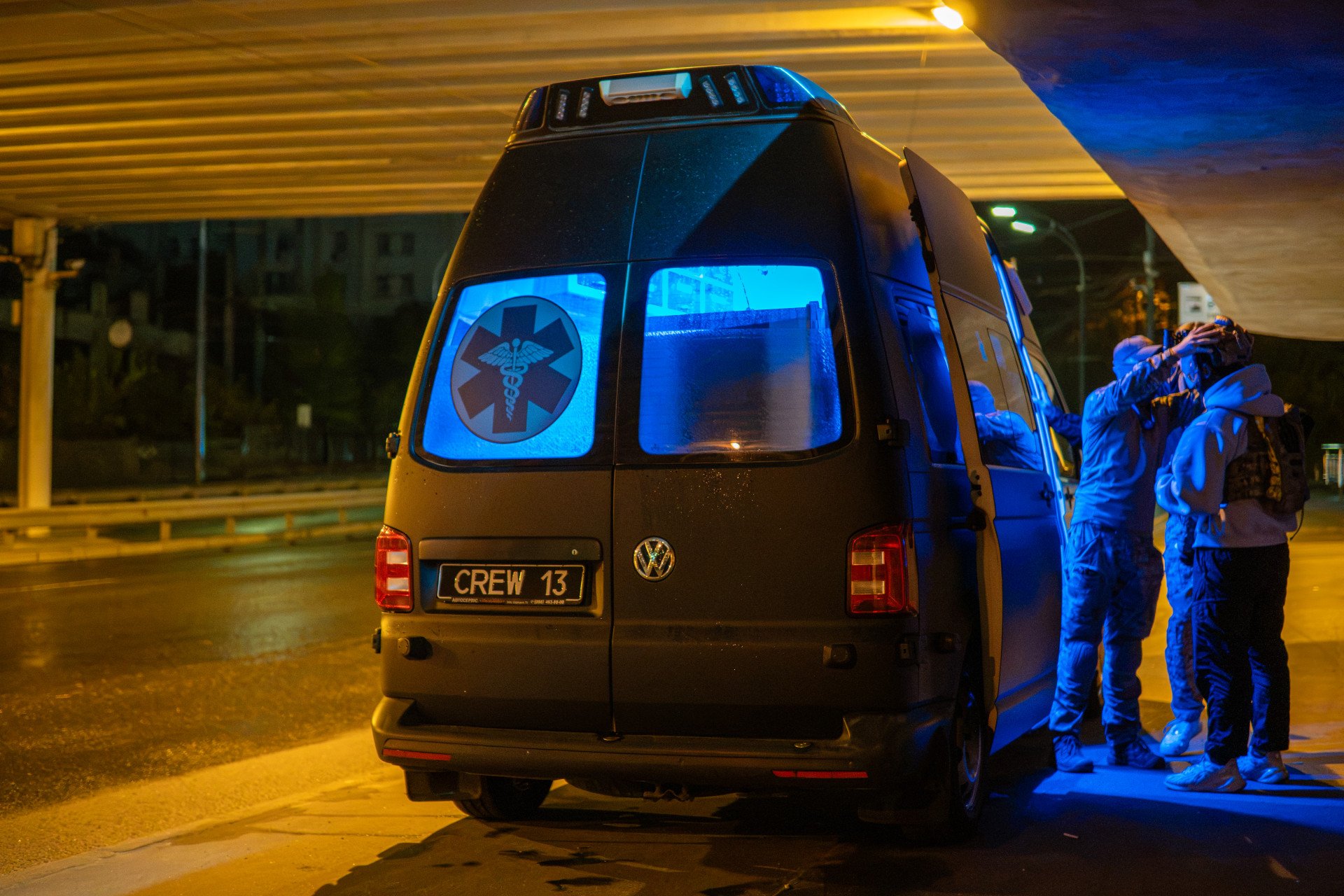 An emergency rescue vehicle belonging to Medical Crew 13 is seen from the rear at a rendezvous point in Kyiv. Ukraine’s young volunteer paramedics utilize this specialized van to rush to the scene of Russian drone and missile strikes across the capital. (Photo: Nikita Lisovyi / UNITED24 Media) Rear view of Medical Crew 13’s emergency medical rescue vehicle stationed at a nighttime rendezvous point in Kyiv.