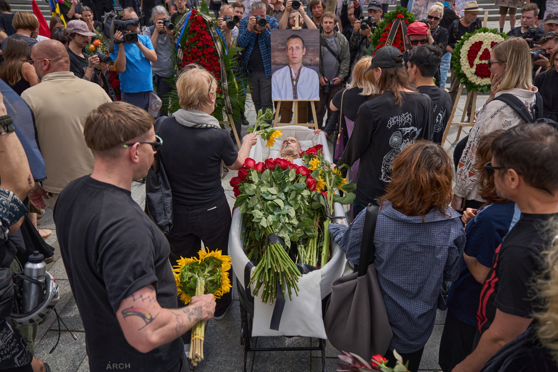 People lay flowers at David’s coffin during the farewell ceremony honoring artist and serviceman David Chichkan at Kyiv’s Independence Square on August 18, 2025, Kyiv, Ukraine. Photo by Mykyta Shandyba/UNITED24 Media.