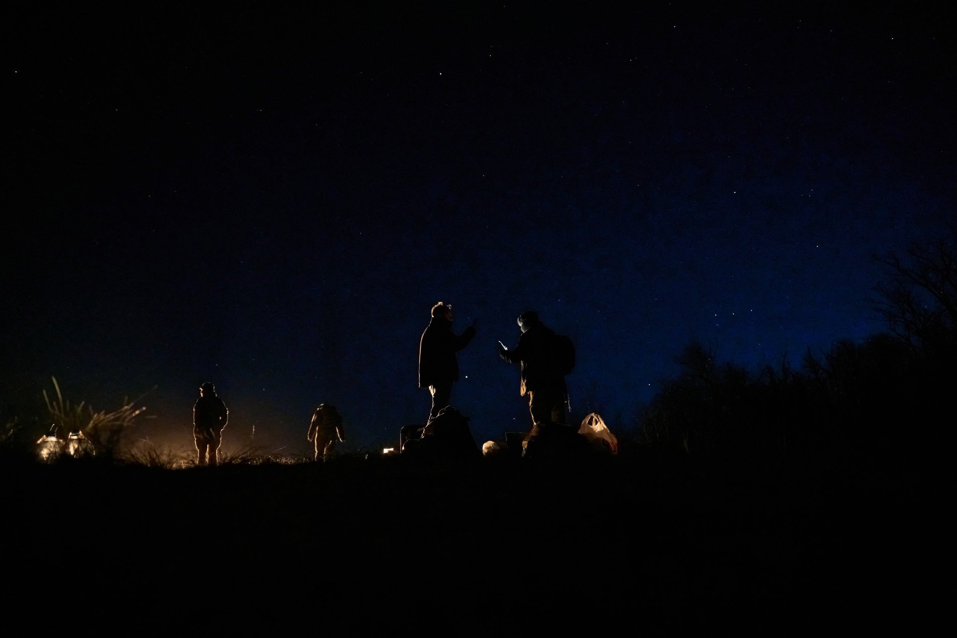 Silueteados contra un cielo estrellado, los cazas preparan el equipo y reciben las últimas instrucciones antes de que comience una operación de entrenamiento nocturno. Silueteados contra un cielo estrellado, los cazas preparan el equipo y reciben las últimas instrucciones antes de que comience una operación de entrenamiento nocturno.