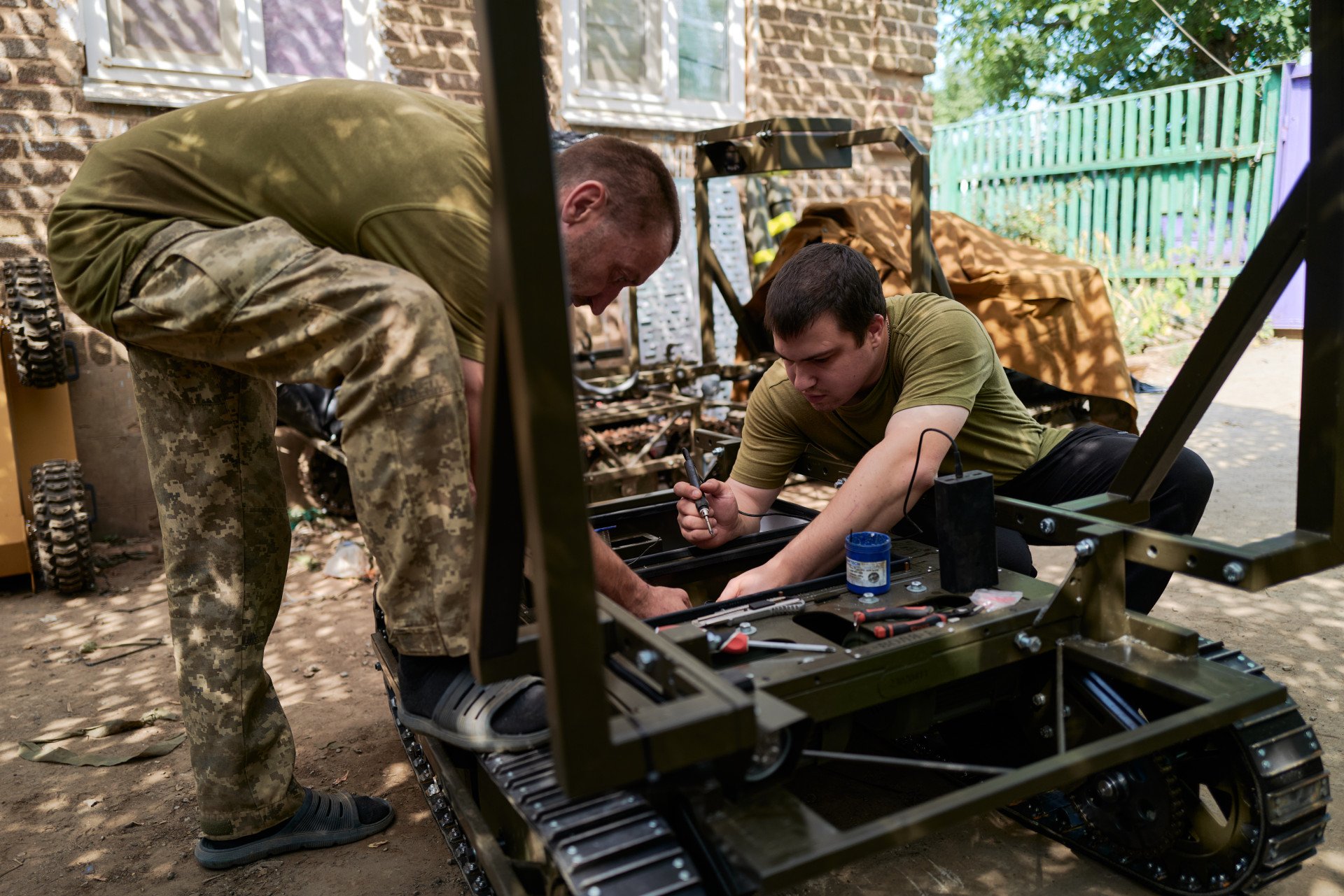 Miembros del servicio de la Compañía de Sistemas Robóticos Terrestres de las Fuerzas Armadas de Ucrania reparan un dron terrestre en una ubicación clasificada el 8 de agosto de 2025 en Ucrania. Foto de Pierre Crom/Getty Images.