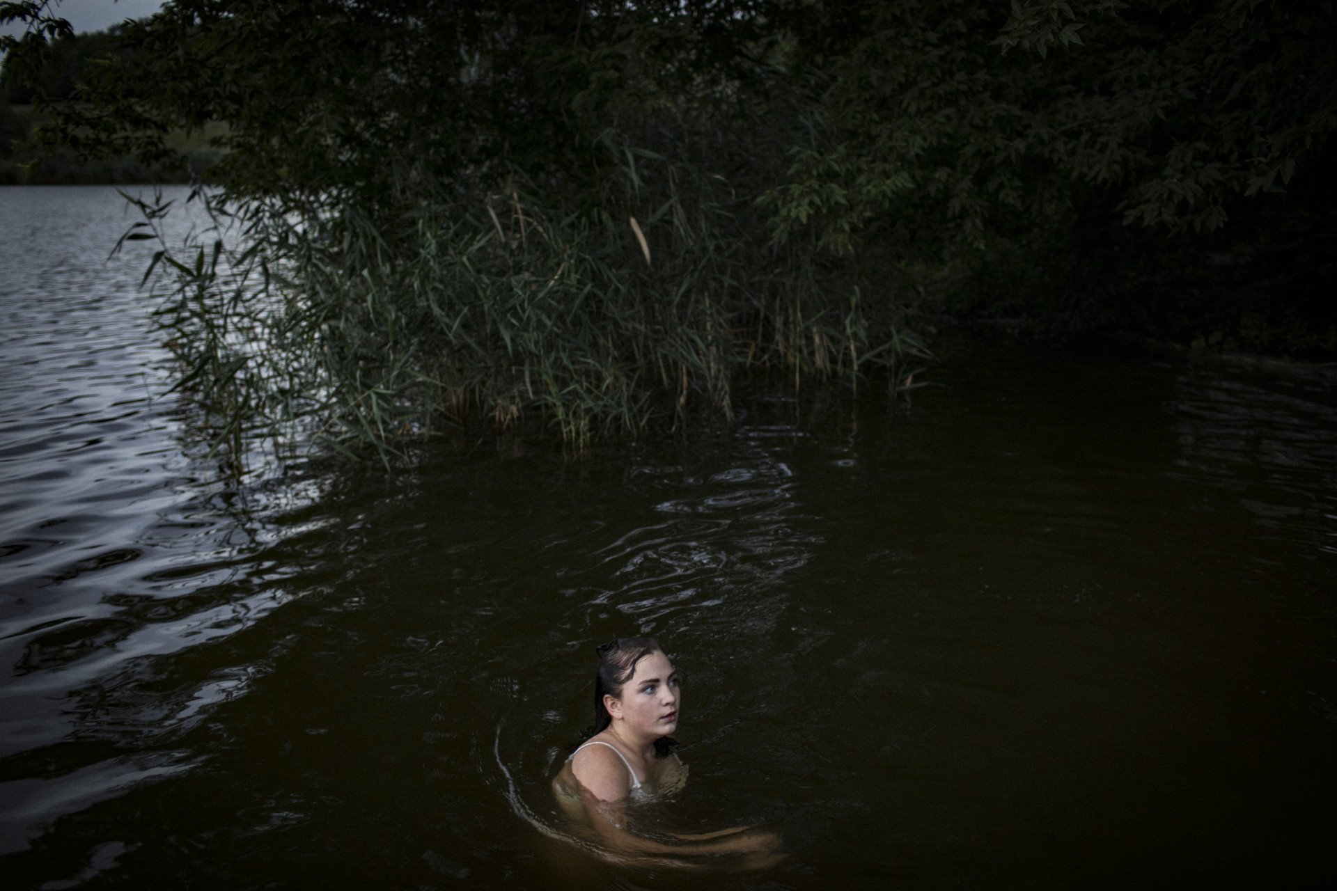 Viktoriia Mountyan, a member of the Hrynyks’ extended family, swimming in a lake near Avdiivka, 2019. From the series 5K from the Frontline. (Image: Anastasia Taylor-Lind) Viktoriia Mountyan, a member of the Hrynyks’ extended family, swimming in a lake near Avdiivka, 2019. From the series 5K from the Frontline. (Image: Anastasia Taylor-Lind)