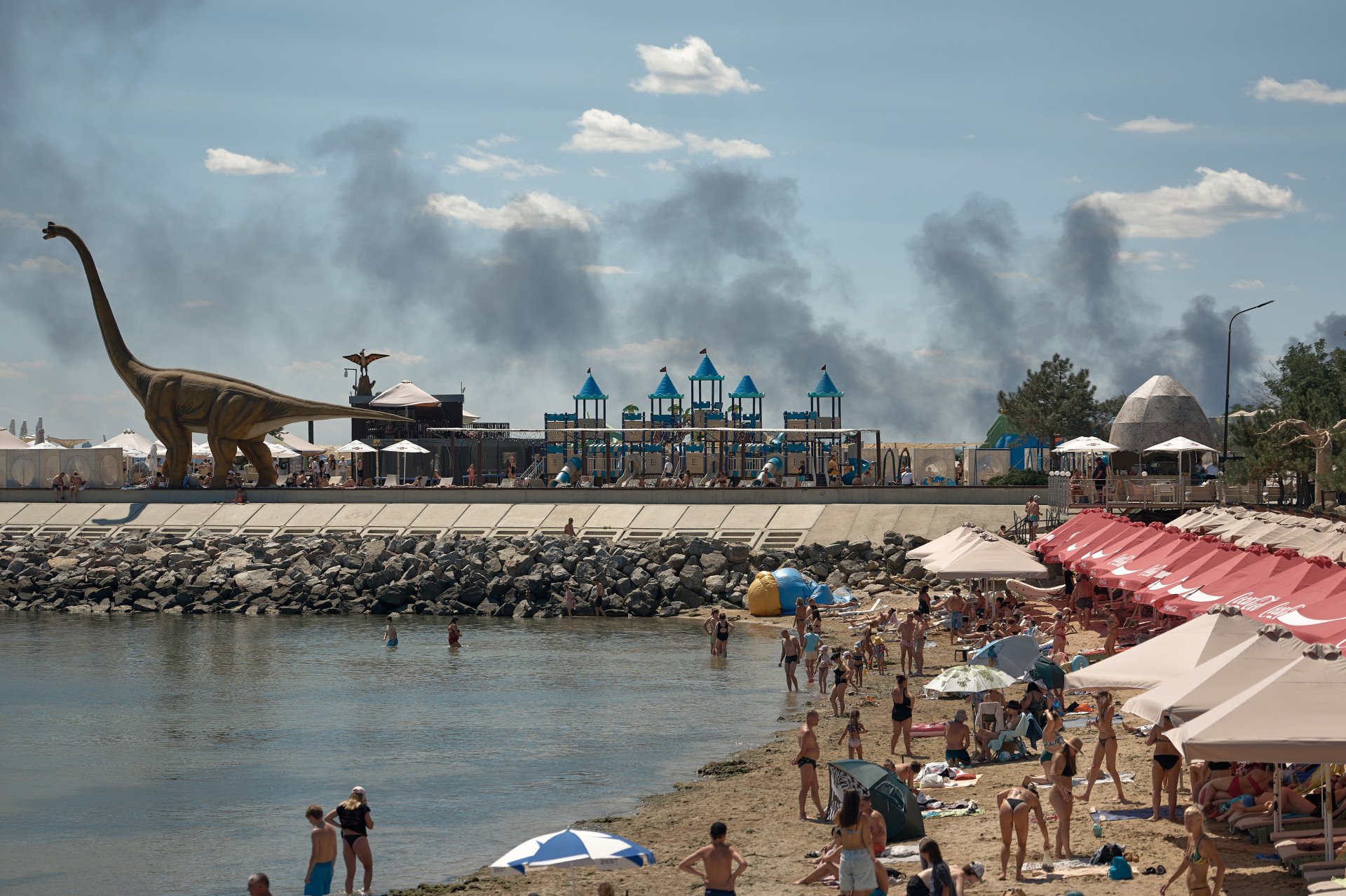 Local residents and visitors relax on a beach on the outskirts of Odesa as smoke from a fire rises in the background following a Russian missile strike during an air raid alert, on July 29, 2026 in Odesa, Ukraine. (Photo by Kostiantyn via Getty Images) Local residents and visitors relax on a beach on the outskirts of Odesa as smoke from a fire rises in the background following a Russian missile strike during an air raid alert, on July 29, 2026 in Odesa, Ukraine. (Photo by Kostiantyn via Getty Images)