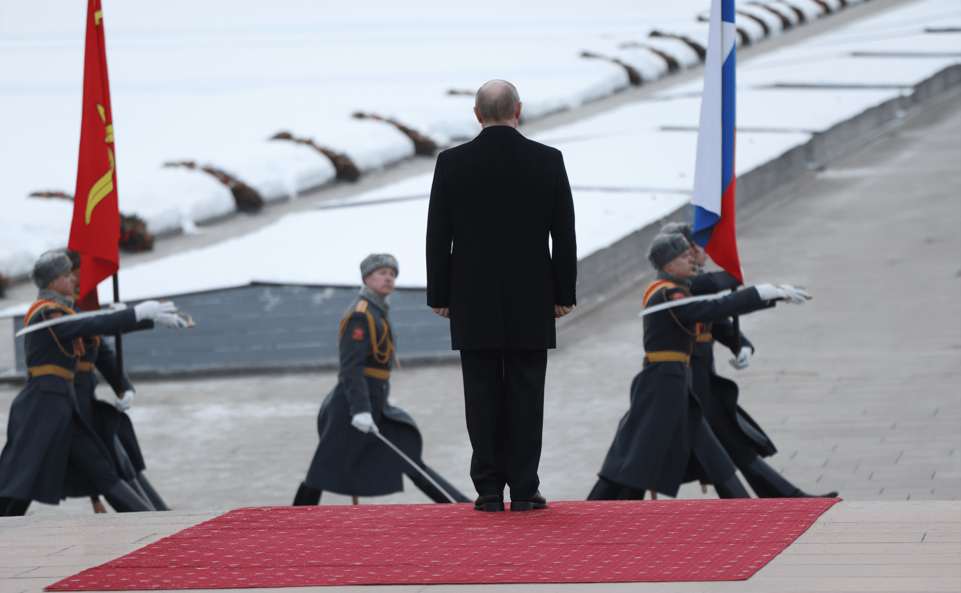 Vladimir Putin stands in front of ceremonial soldiers