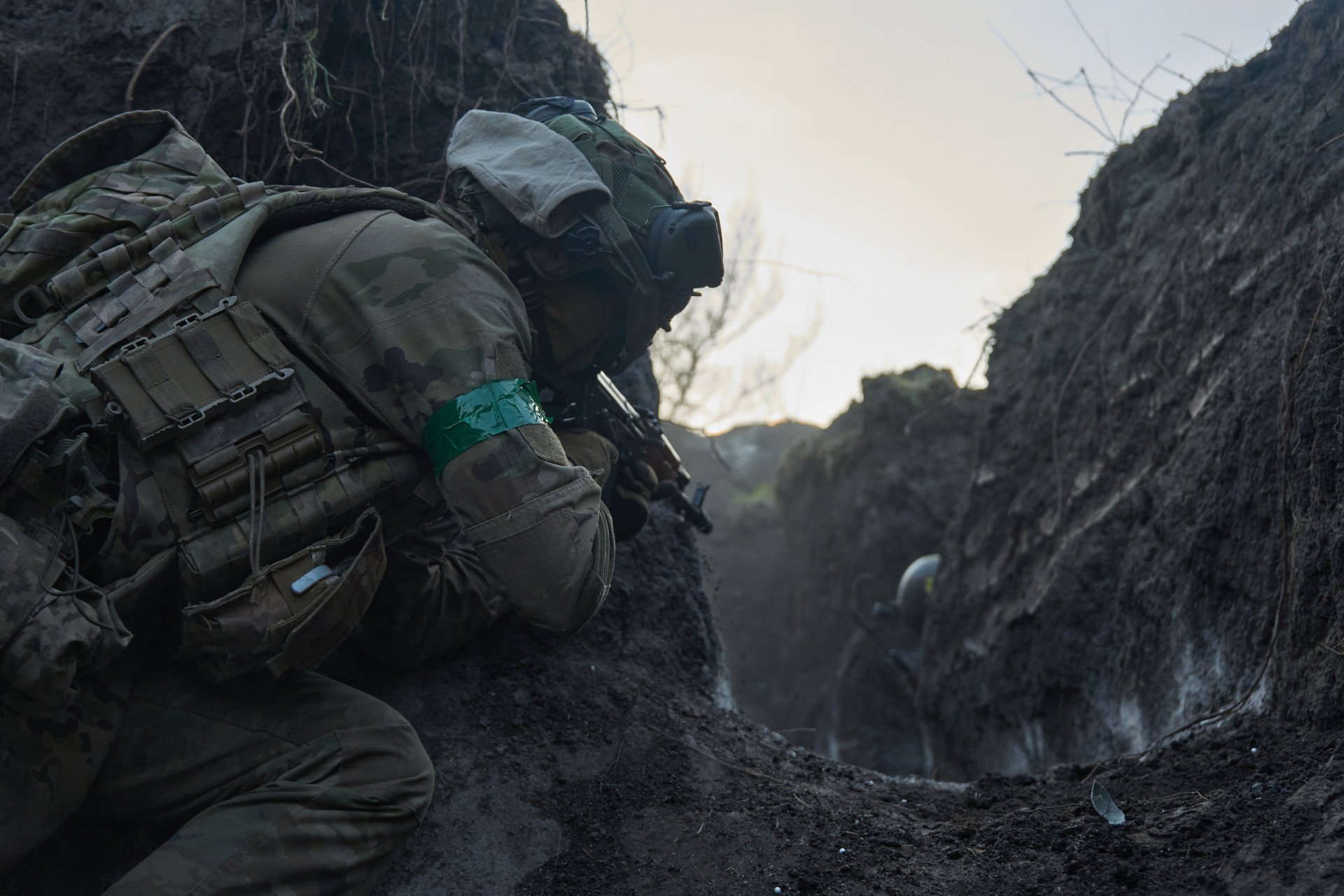 Un combatiente extranjero se pone a cubierto junto al muro de una trinchera, con el arma preparada, durante un simulacro de combate cuerpo a cuerpo en el que se simulan asaltos en primera línea en Ucrania. Un combatiente extranjero se pone a cubierto junto al muro de una trinchera, con el arma preparada, durante un simulacro de combate cuerpo a cuerpo en el que se simulan asaltos en primera línea en Ucrania.