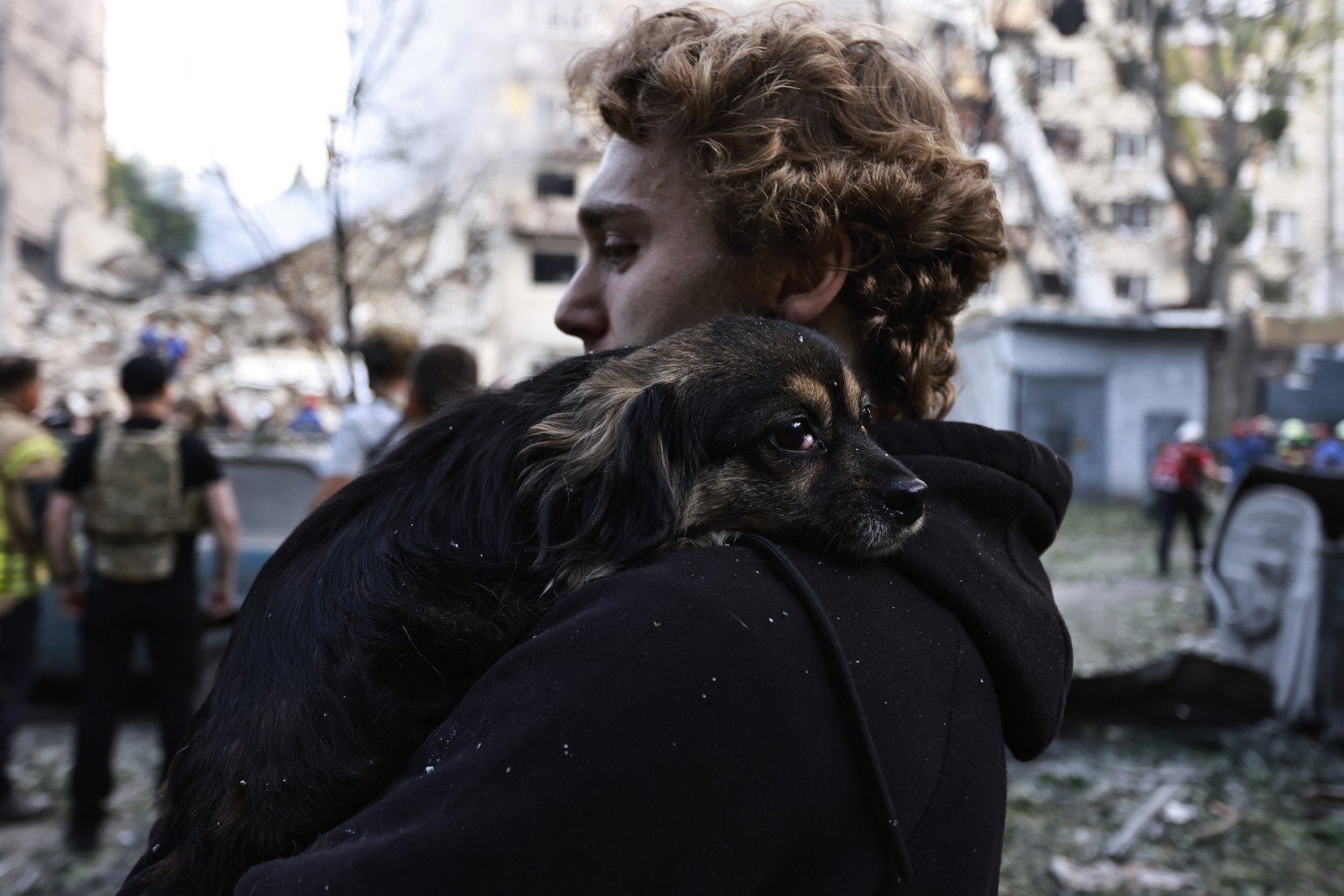 A man holds dog in front of partially collapsed residential building after Russian drone-and-missile attack on June 17, 2025 in Kyiv, Ukraine. Rescuers continue to search for people under the rubble. (Photo by Yan Dobronosov via Getty Images)