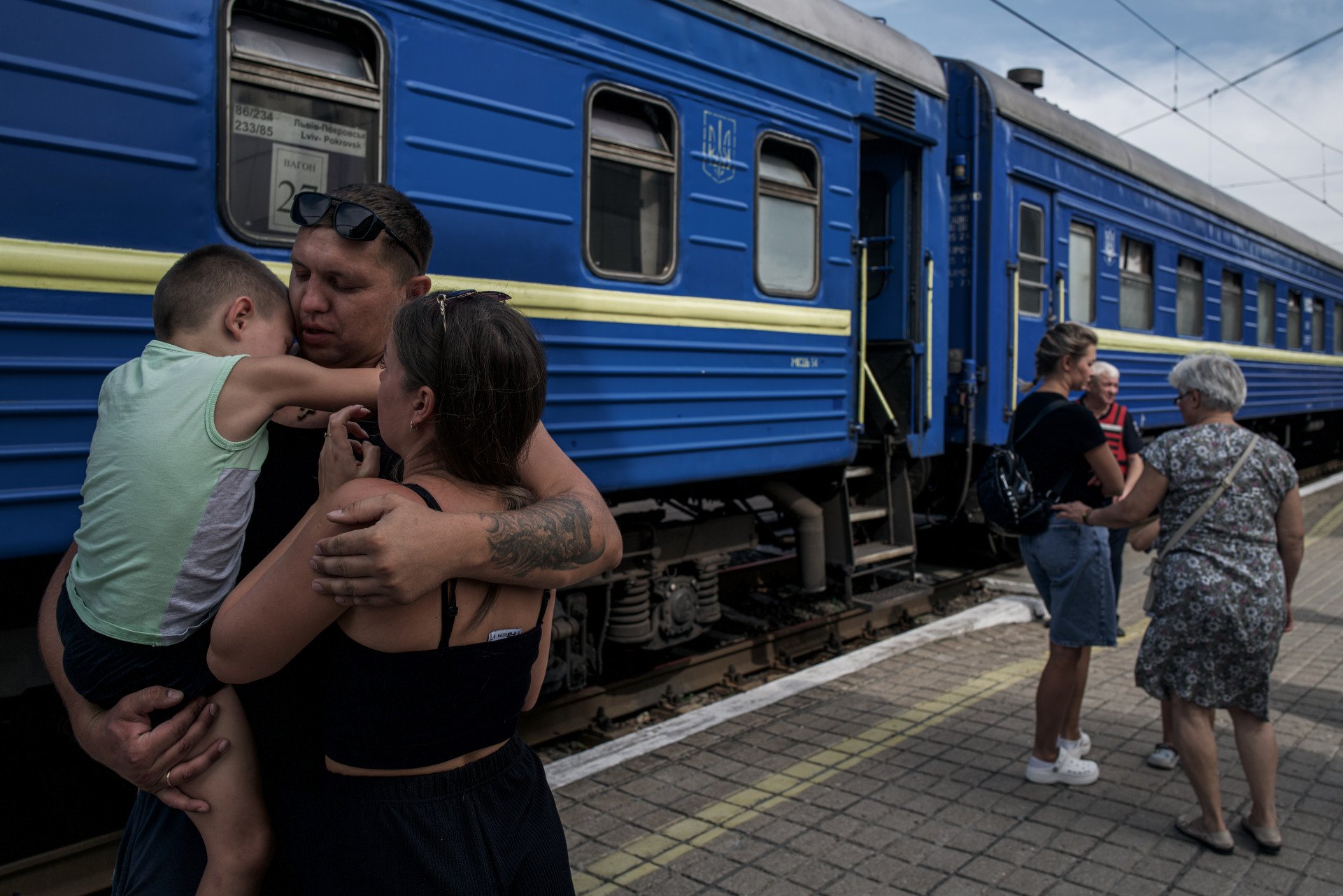 A father hugs his family before they board the evacuation train from Pokrovsk