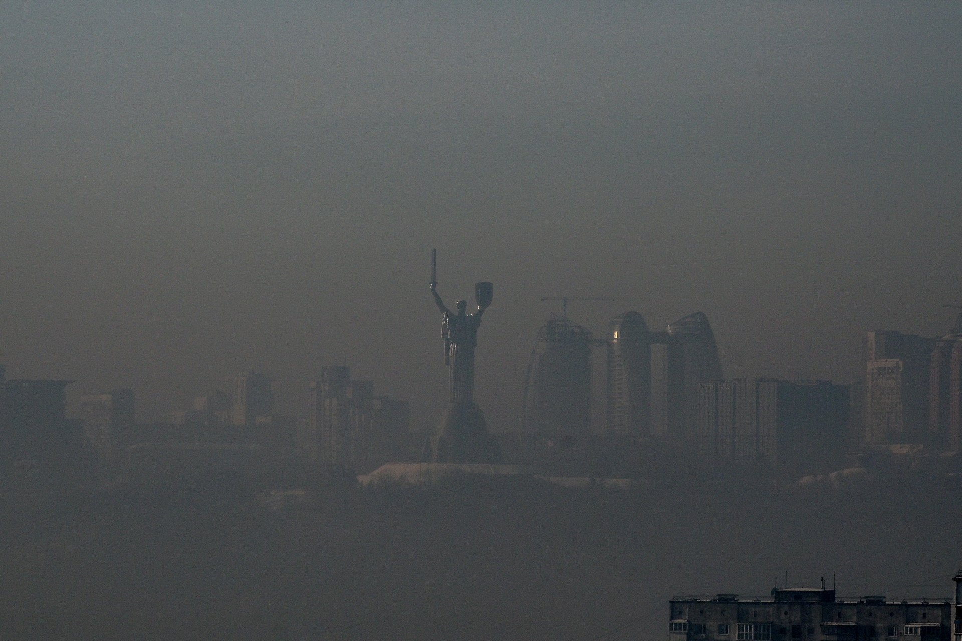 The Motherland Monument is enveloped in smog after a missile and drone attack in Kyiv on January 20, 2026, causing fires, power and water disruptions, and leaving over 5,600 buildings without heating (Photo by Yevhen Kotenko/Ukrinform/NurPhoto via Getty Images).