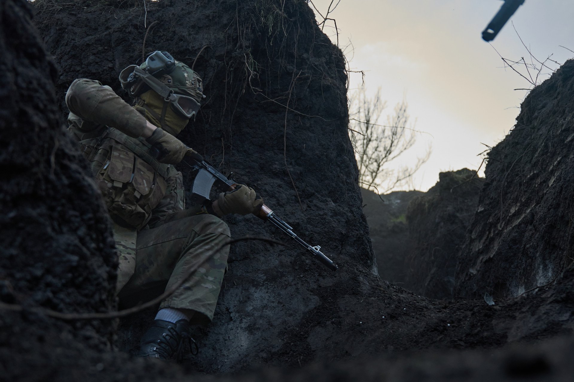 Un combatiente extranjero se pone a cubierto junto al muro de una trinchera, con el arma preparada, durante un simulacro de combate cuerpo a cuerpo en el que se simulan asaltos en primera línea en Ucrania. Un combatiente extranjero se pone a cubierto junto al muro de una trinchera, con el arma preparada, durante un simulacro de combate cuerpo a cuerpo en el que se simulan asaltos en primera línea en Ucrania.