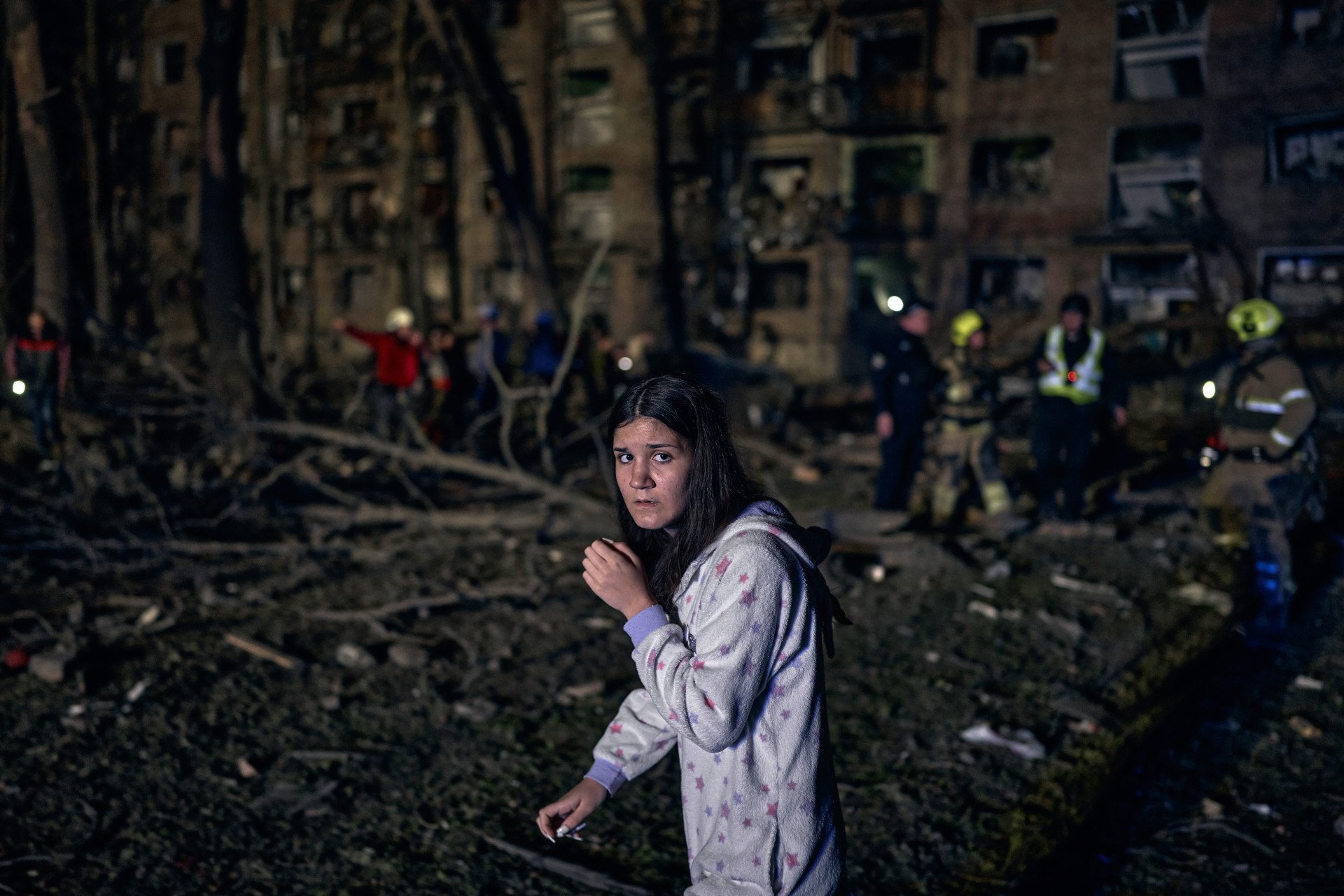 Still in pajamas, a young woman stands in shock amid the rubble of her home. Russia’s missile turned her neighborhood into a disaster zone on April 24, 2025, in Kyiv, Ukraine. (Photo by Kostiantyn Liberov/Libkos/Getty Images)