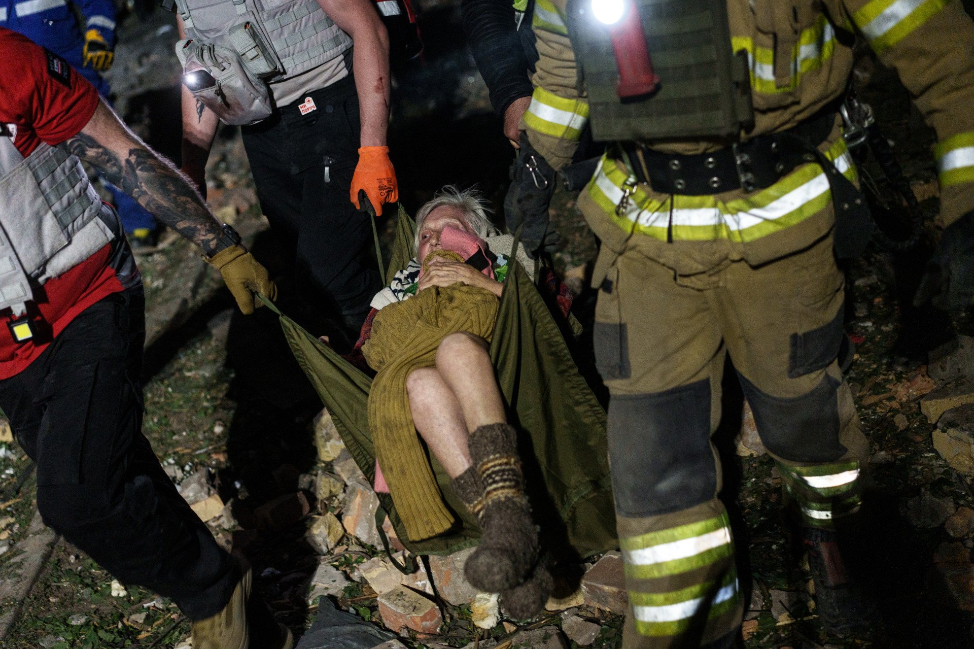Step by careful step, rescuers carry an injured elderly woman from the wreckage of a residential building in Kyiv, Ukraine, on April 24, 2025. (Photo: Serhii Korovayny @serhiikorovayny )