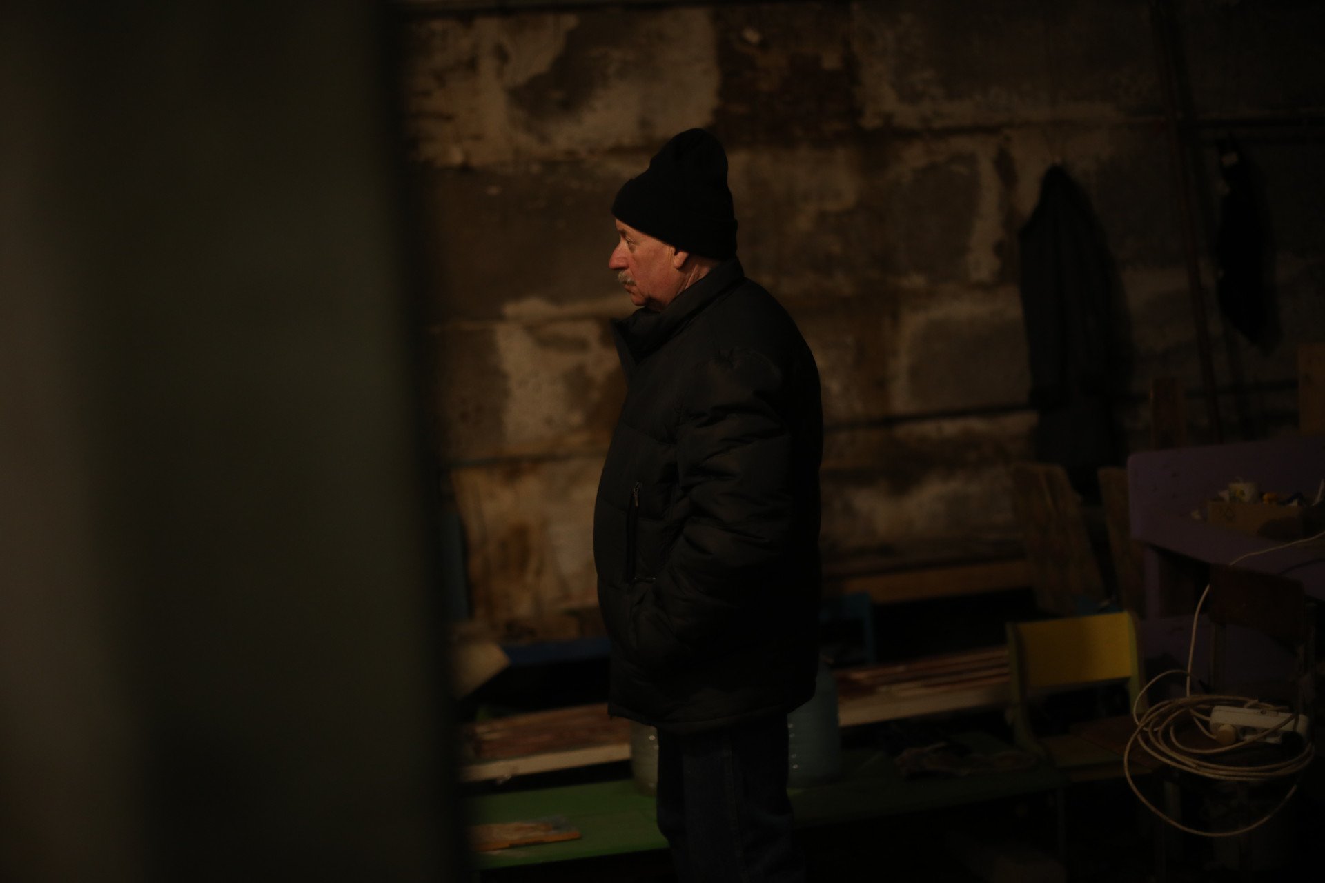 Ivan Polhui, 65, stood watchfully with his hands in his pockets. He had worked at the Yahidne school before Russia’s full-scale invasion of Ukraine, responsible for maintenance and security. Now, he guides people to the basement, offering insight and pointing to spots where people passed away. (Photo: Lucile Brizard)